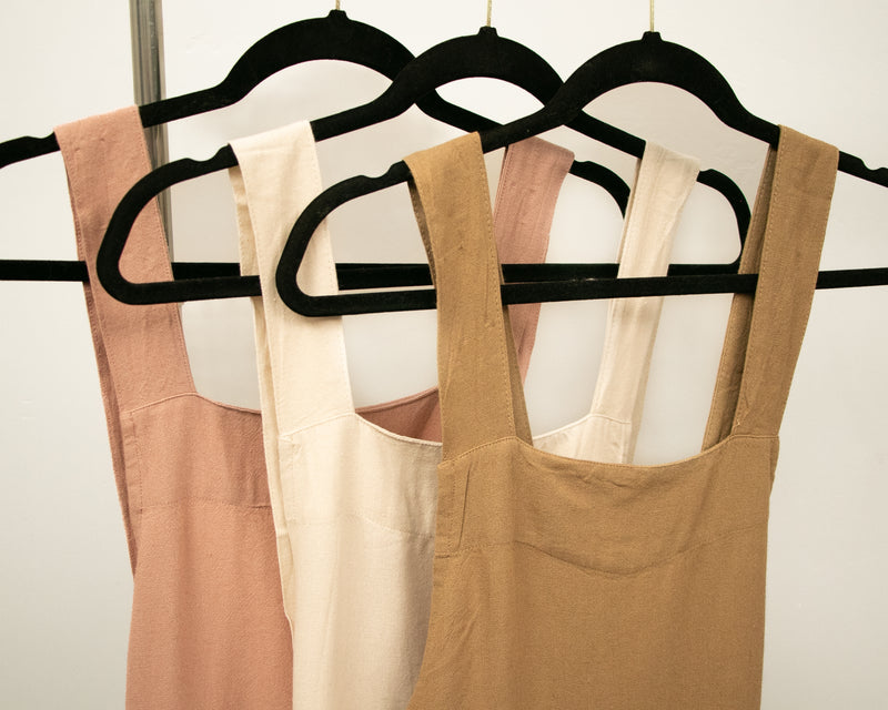three different colored tops hanging on a rack